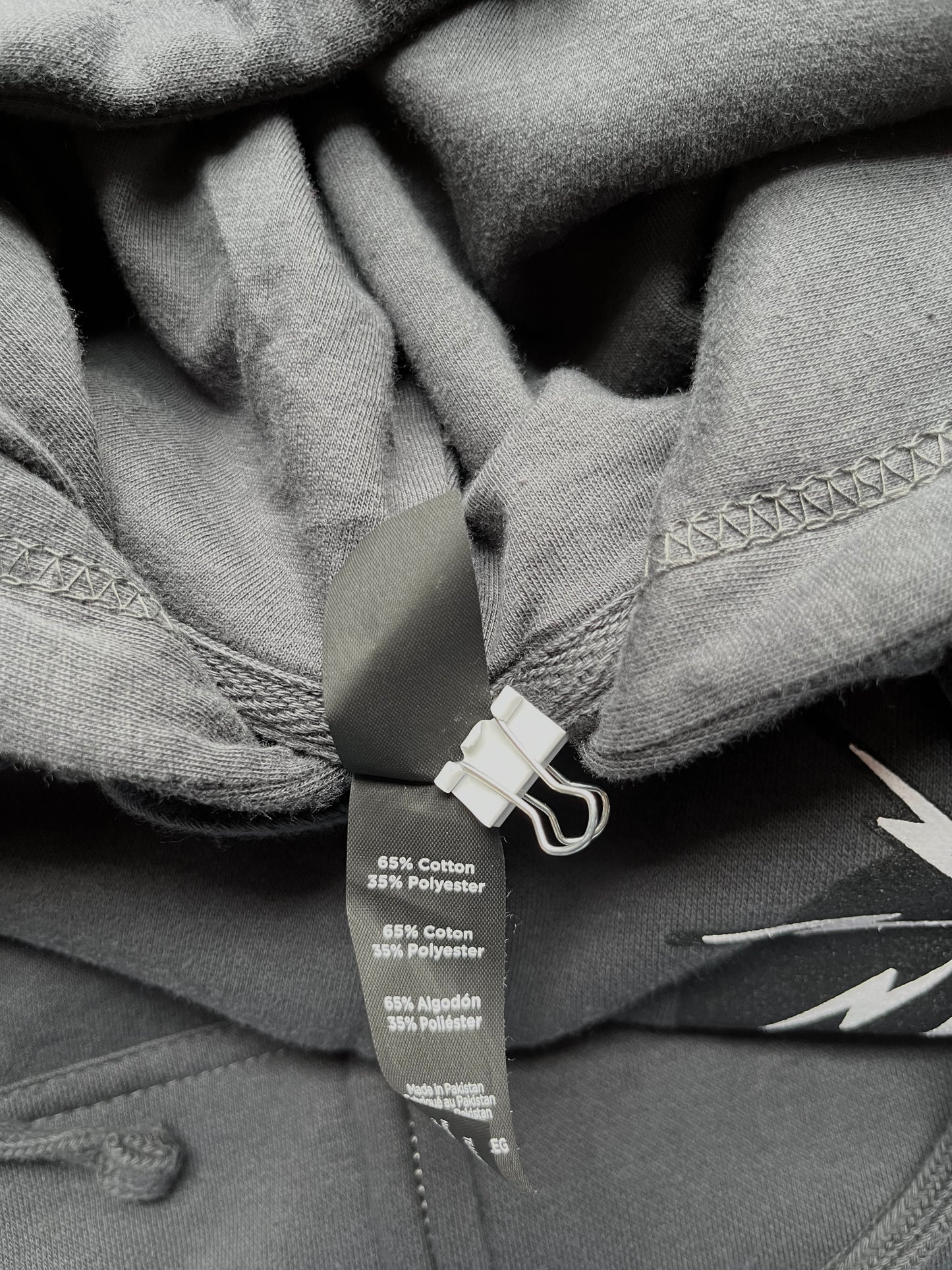 Close up of tag: Trading Heavyweight Zip Hooded Sweatshirt (70% Cotton/30% Polyester with 100% Cotton 32 singles face yarn for supreme printability and softness).