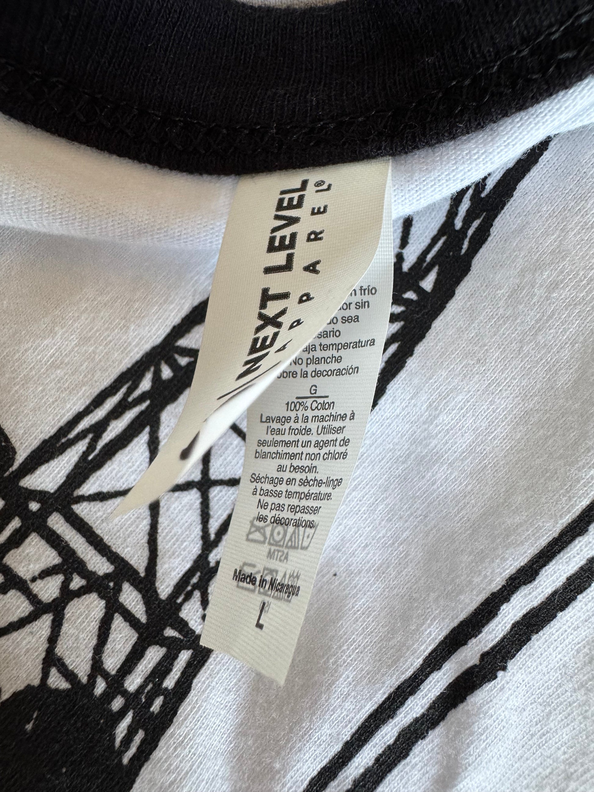 Close-up of a clothing tag on a black and white patterned fabric.